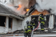 Firefighters work on gaining access to hit flames during a house fire in Barrington Hills IL. Larry Shapiro photo