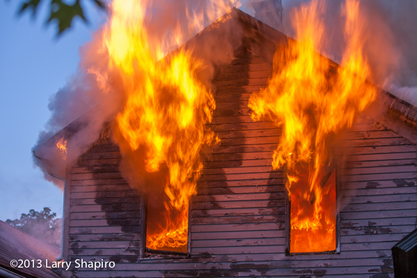 photo of fire blosing out of house windows