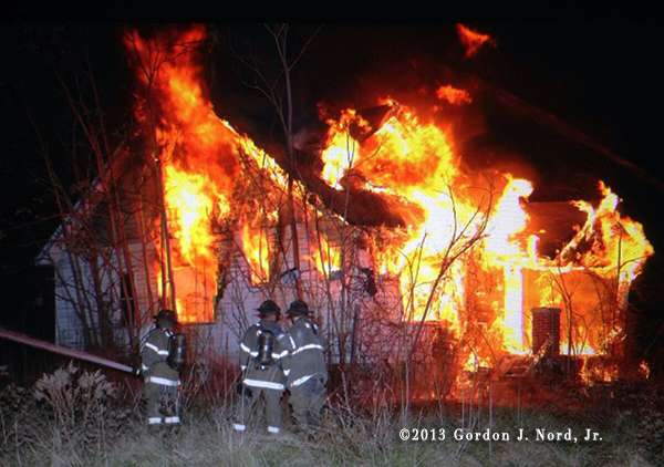 Detroit firemen battle vacant house fire at night