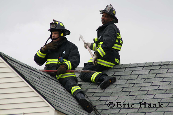 Chicago firemen straddle roof during fire