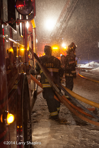 firemen battle house fire in snow storm at night