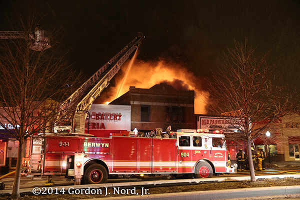Seagrave quint working at night fire scene with big flames