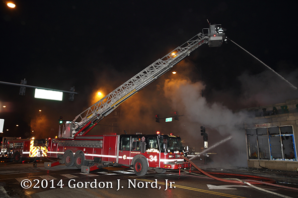 Chicago FD E-ONE Tower Ladder 34 working at a night fire scene