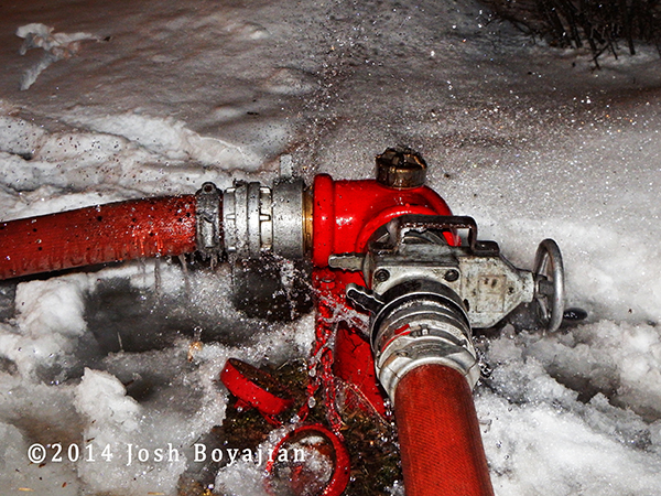 fire hydrant in the snow with hose attached