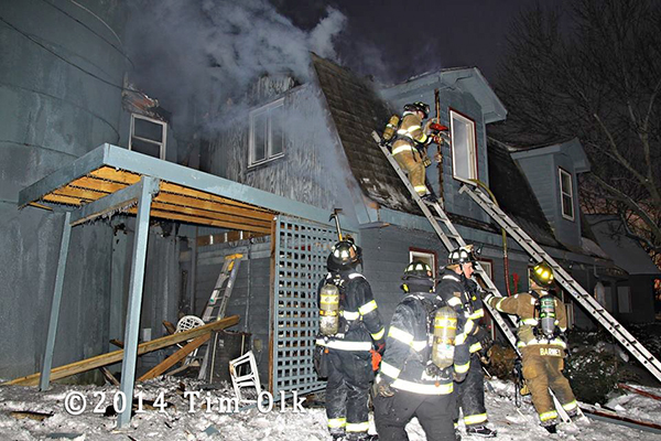 firemen on ladders at winter fire scene