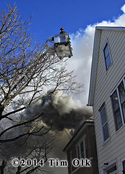 firemen in tower ladder bucket at fire scene