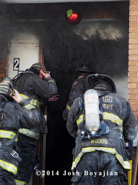 firemen prepare to enter a burning building