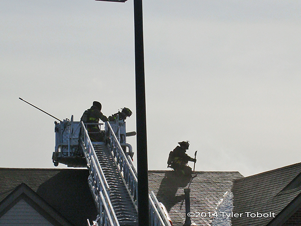 firemen working on roof of building
