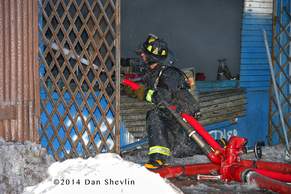 iceman with fire hose at fire scene