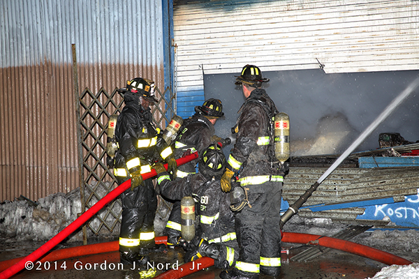 firemen with hose at fire scene