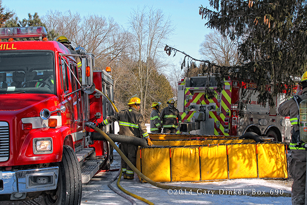 fire engine drafts from portable tank at winter fire