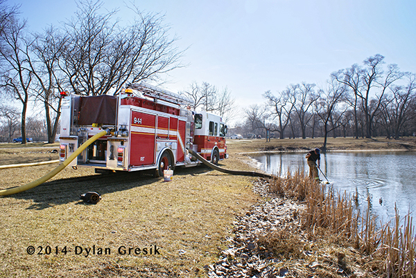 fire engine drafting water from a pond
