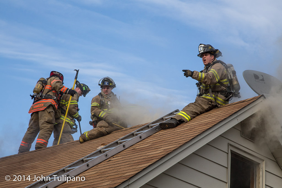 firemen on roof at house fire