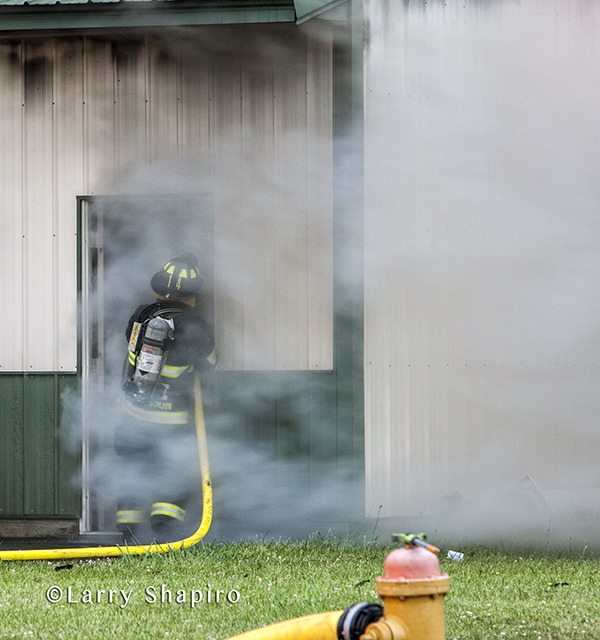 fireman with hose and smoke