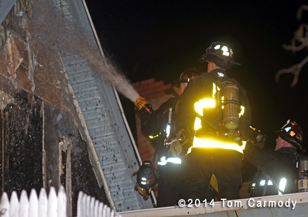 Boston firemen with hose at night fire scene
