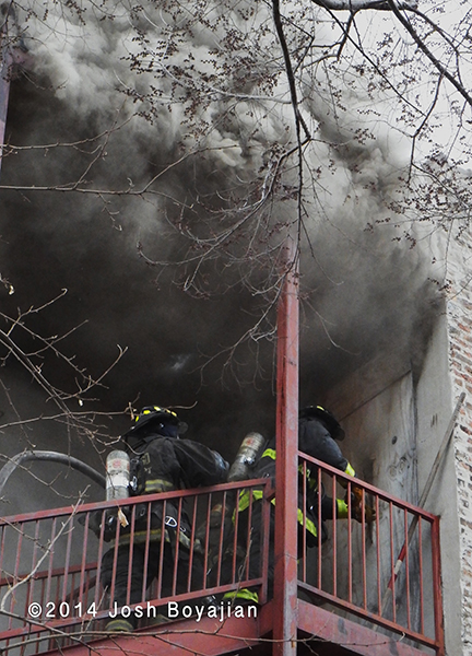 firemen make entry with heavy smoke overhead