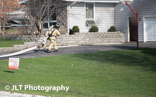 fireman pulling hose at fire scene