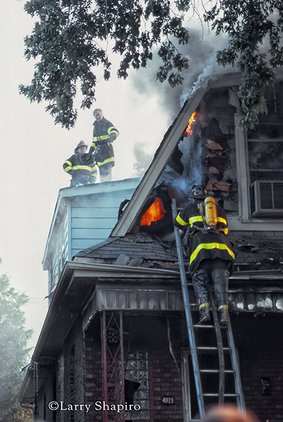 firemen battle a house fire with smoke and flames