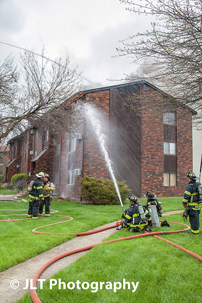 firemen throw water at building fire