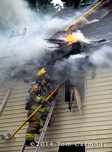 fireman on graound ladder with smoke and flames