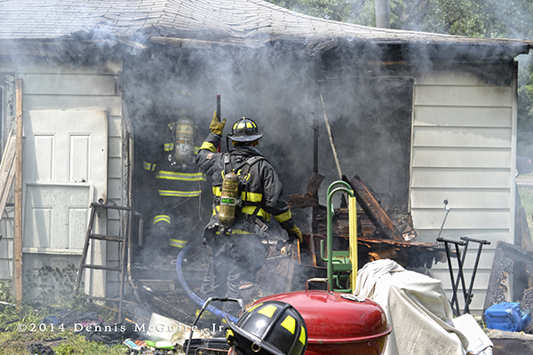 firemen working at a house fire scene