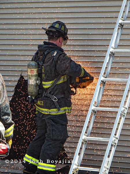 Chicago fireman cuts metal door with saw