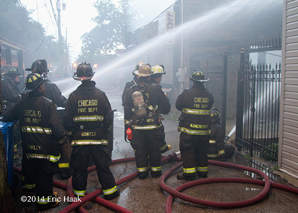 Chicago firemen operate hoselines at fire scene
