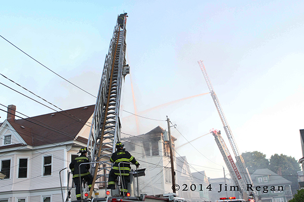 aerial ladder pipes working at fire scene 
