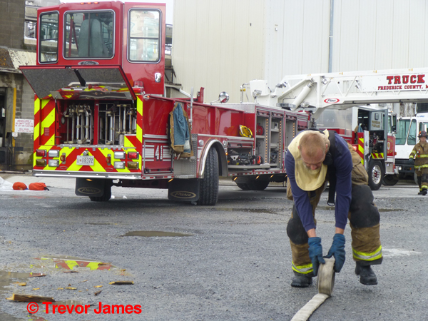 fireman rolls hose after a fire