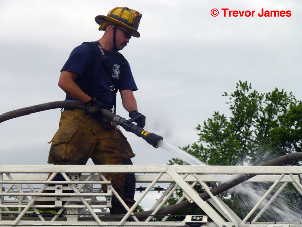 fireman cleans ladder truck after fire