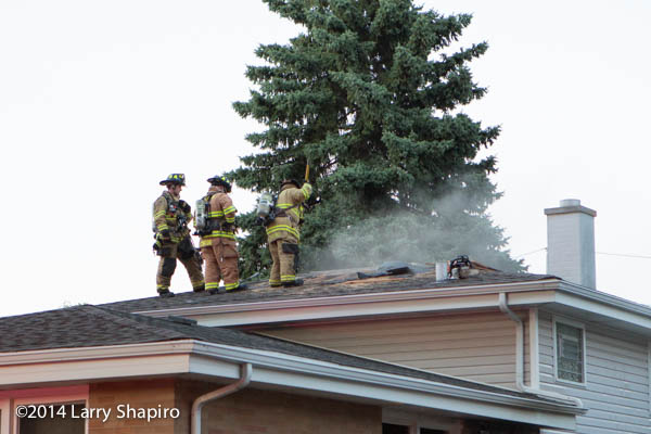 firemen ventilate roof of a house