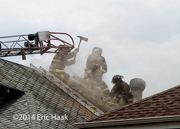 Chicago firemen venting the roof of a house