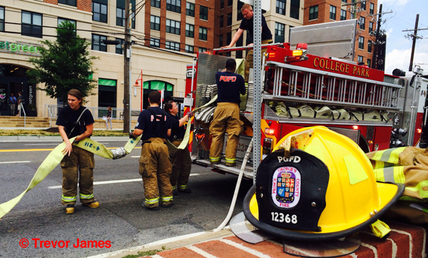 firemen repack hose on fire engine