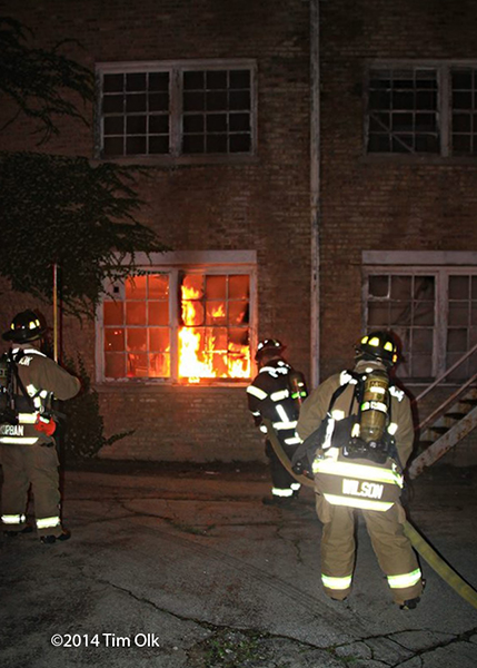 firemen with hose line attacking a fire
