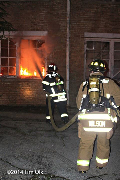 firemen with hose line attacking a fire