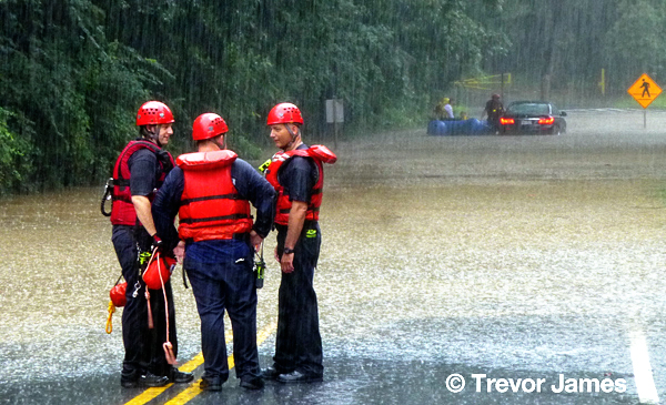 firemen rescue a woman trapped during a storm