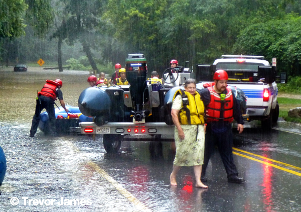 firemen rescue a woman trapped during a storm