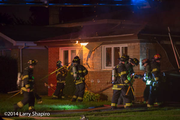 firemen work at house fire at night