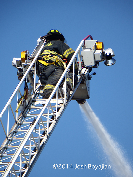 fireman on aerial ladder tip with master stream