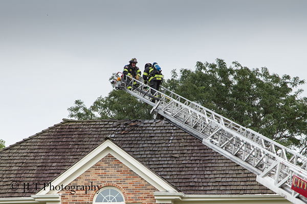 firemen on the tip of an aerial ladder