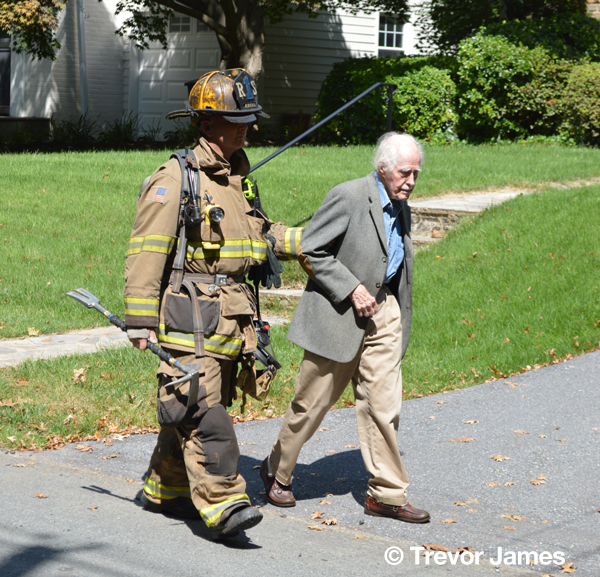 firefighter escorts elderly man