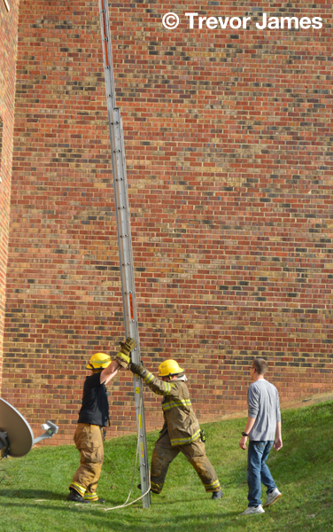 firemen with ladder at fire scene