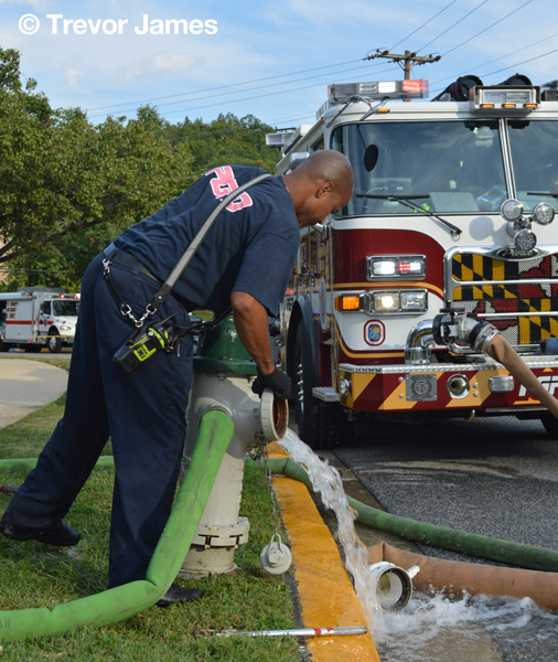 firemen with hose at hydrant
