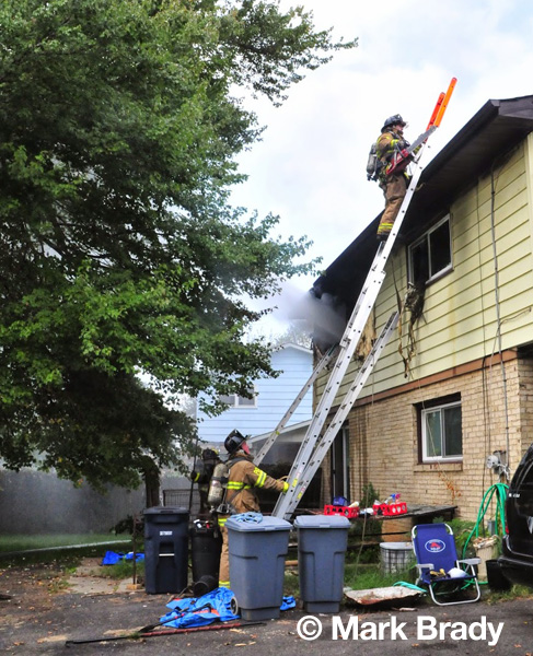 fireman on a ladder to the roof of a house fire