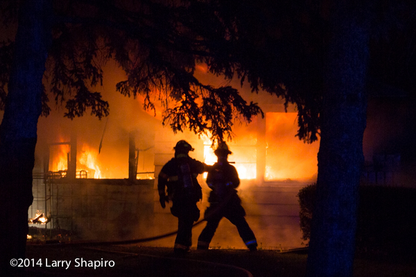 silhouette of firefighters at house fire