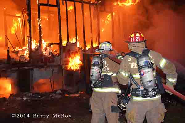 firemen battle mobile home fire at night