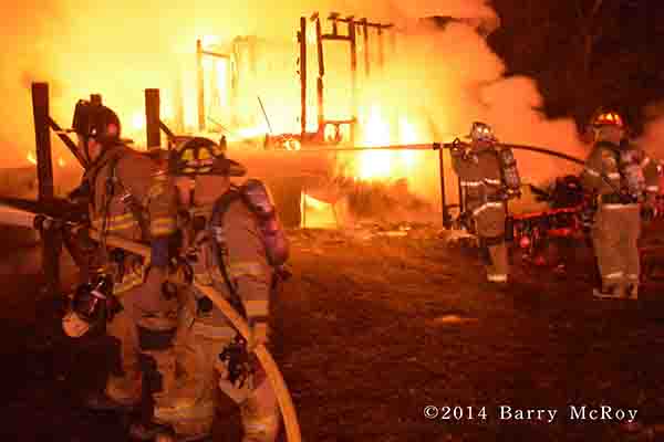 firemen battle mobile home fire at night