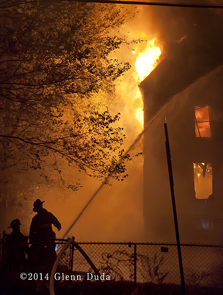 silhouette of firemen at night fire scene