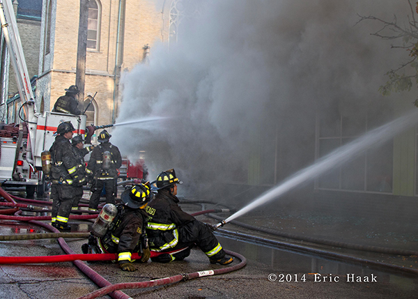 firefighters with hose line a t fire scene