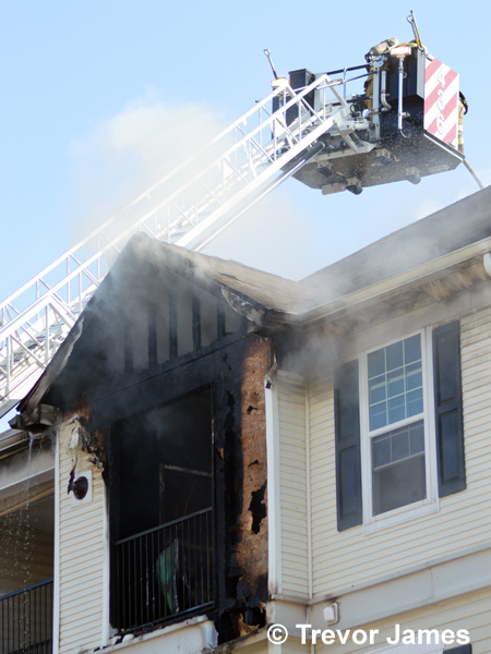 tower ladder in use at townhouse fire